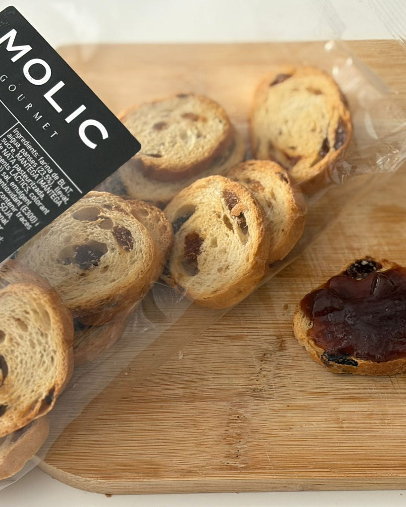 Pan especial tostado con pasas de la marca Delicat Aliment, mostrando rebanadas con pasas en un plato.